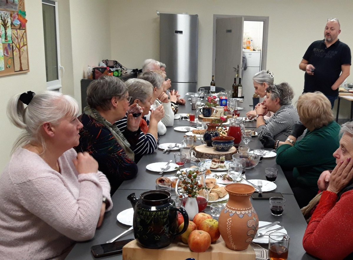 uczestnicy Klubu Seniora przy stole z potrawami gruzińskimi