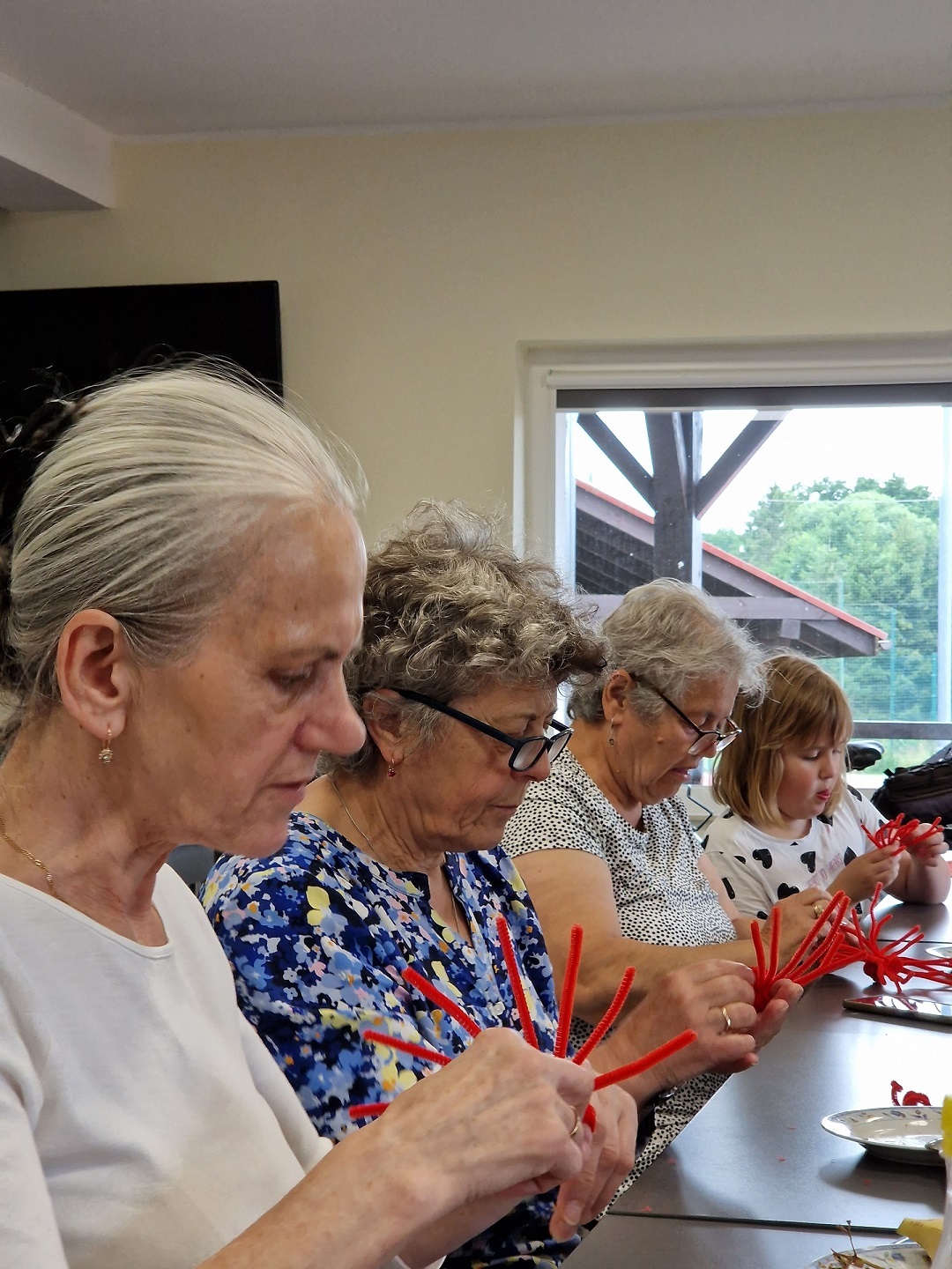 uczestniczki Klubu Seniora przy stole podczas zajęć rękodzielniczych