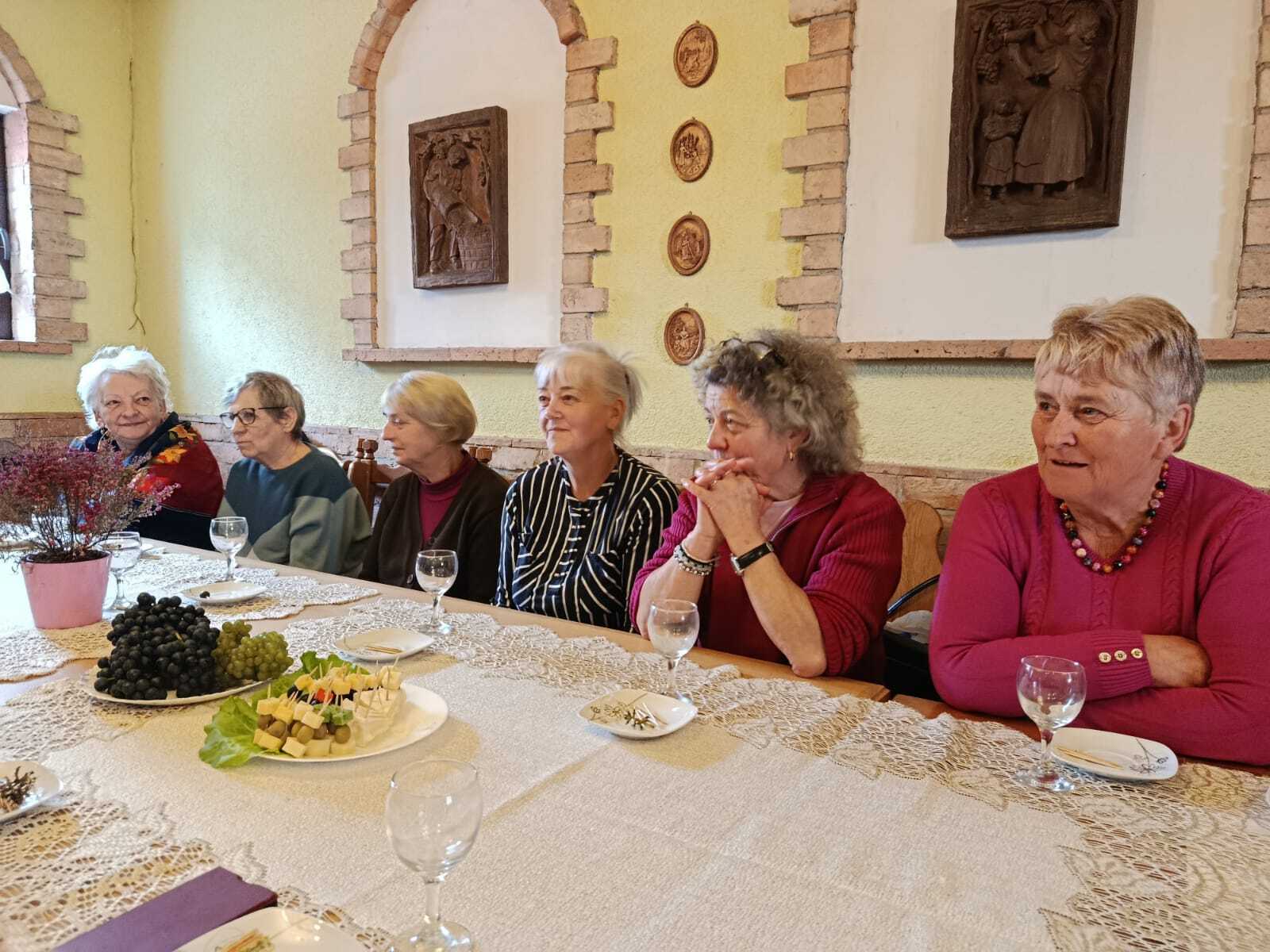 zdjęcie przedstawia sześć uśmiechniętych uczestniczek spotkania siedzącyc przy stole