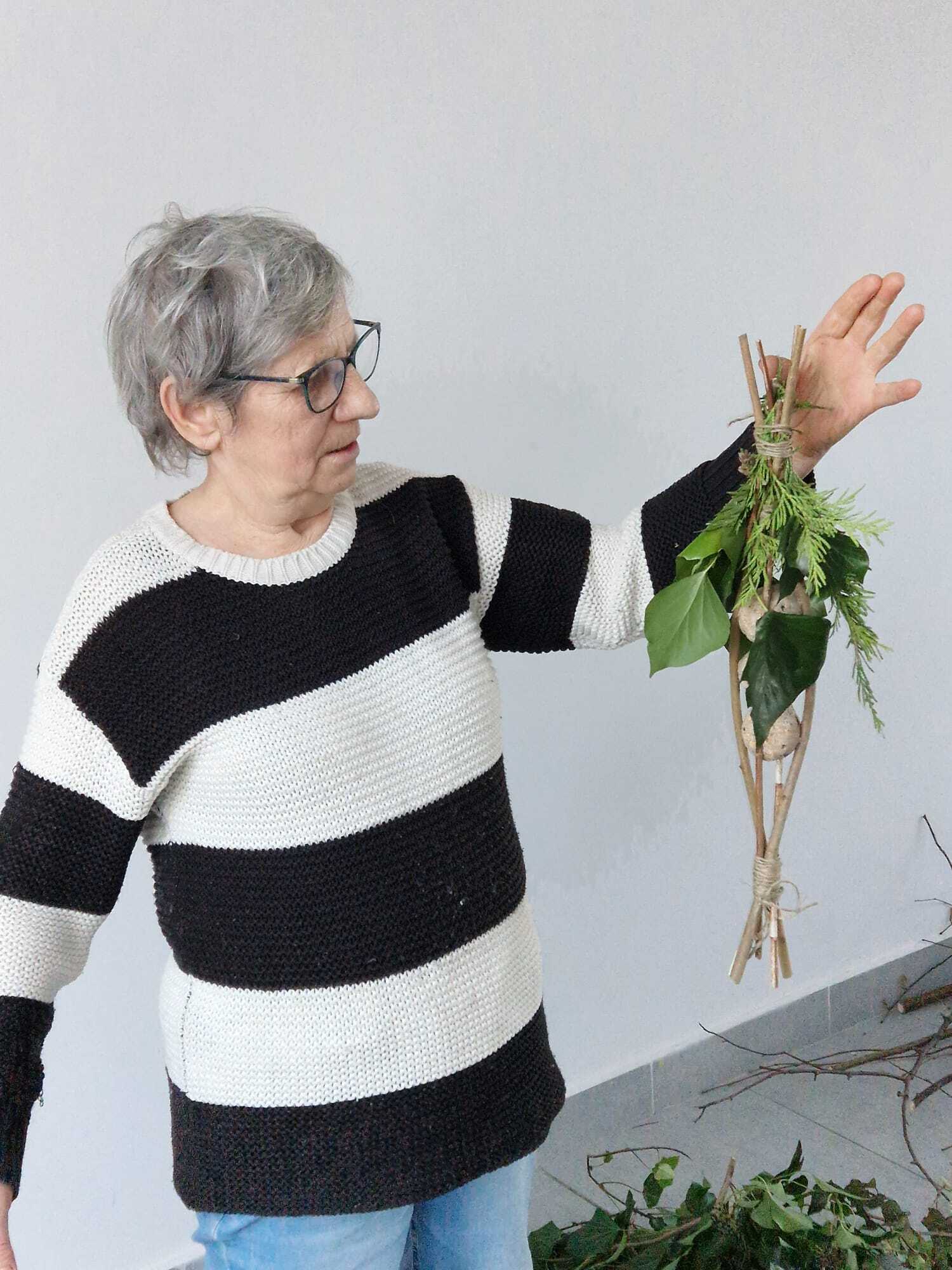 uczestniczka warsztatów staojąca i prezentująca w dłoni gotowy karmnik dla ptaków