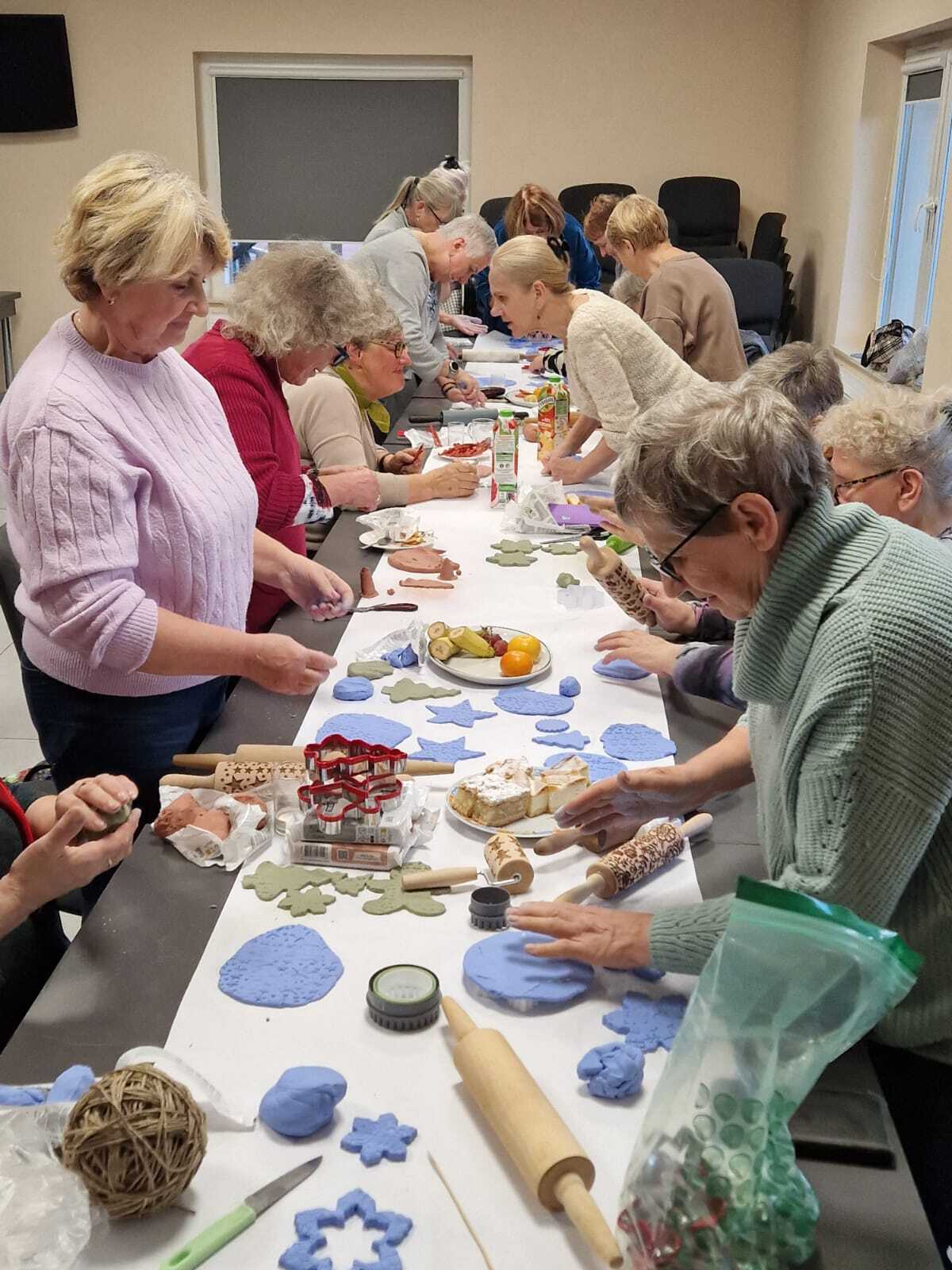 uczestniczki warsztatów przy wspólnym stole tworzące ozdoby ceramiczne