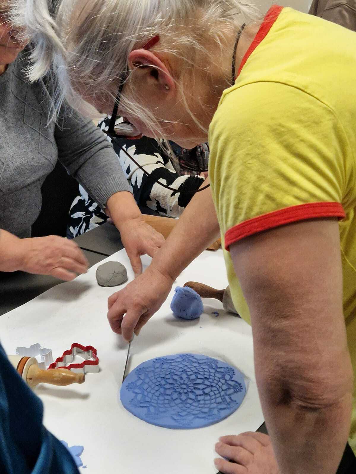 uczestniczki warsztatów przy wspólnym stole tworzące ozdoby ceramiczne