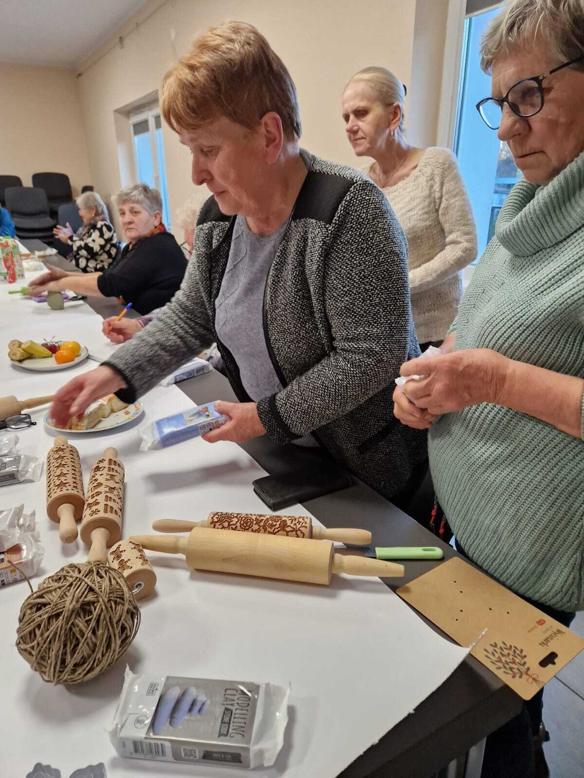uczestniczki warsztatów przy wspólnym stole tworzące ozdoby ceramiczne
