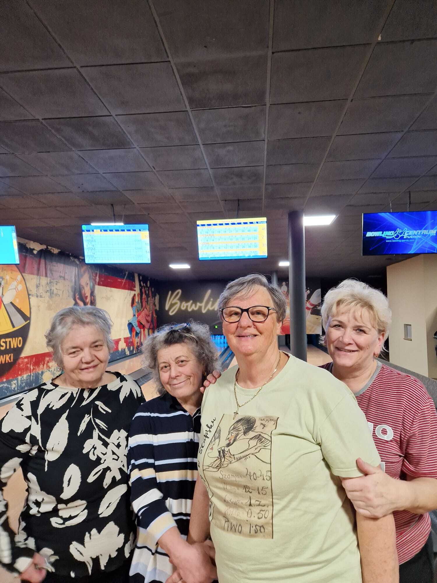 zdjęcie przedstawia stojące przy sobie cztery uczestniczki spotkania, w tle tory do gry w kręgle