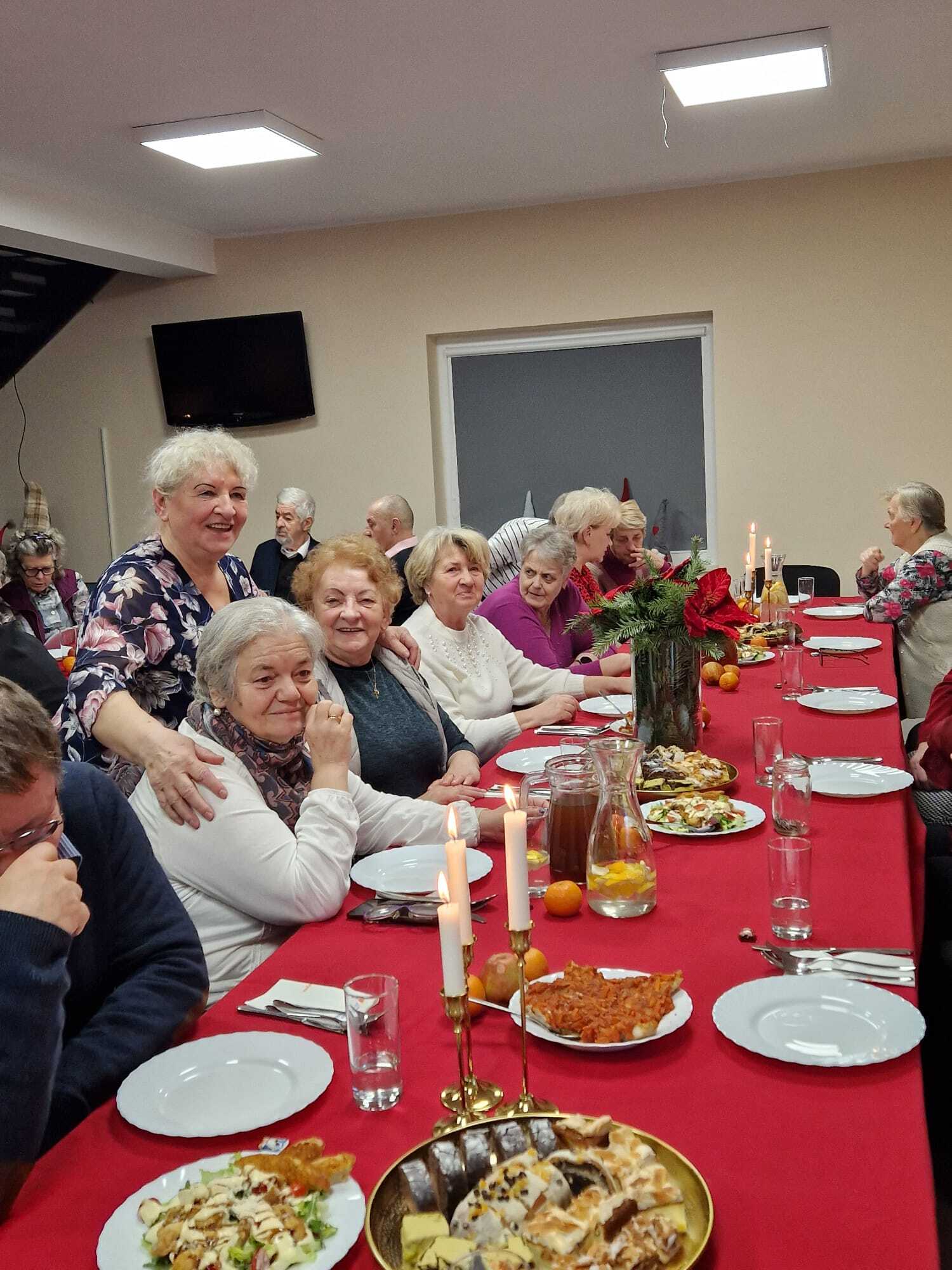 uczestniczki spotkania siedzące przy wspólnym stole mikołajkowym