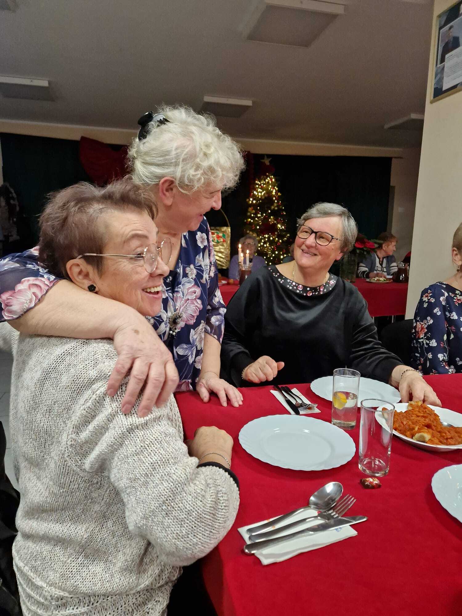 uśmiechnięte trzy uczestniczki spotkania przy stole mikołajkowym