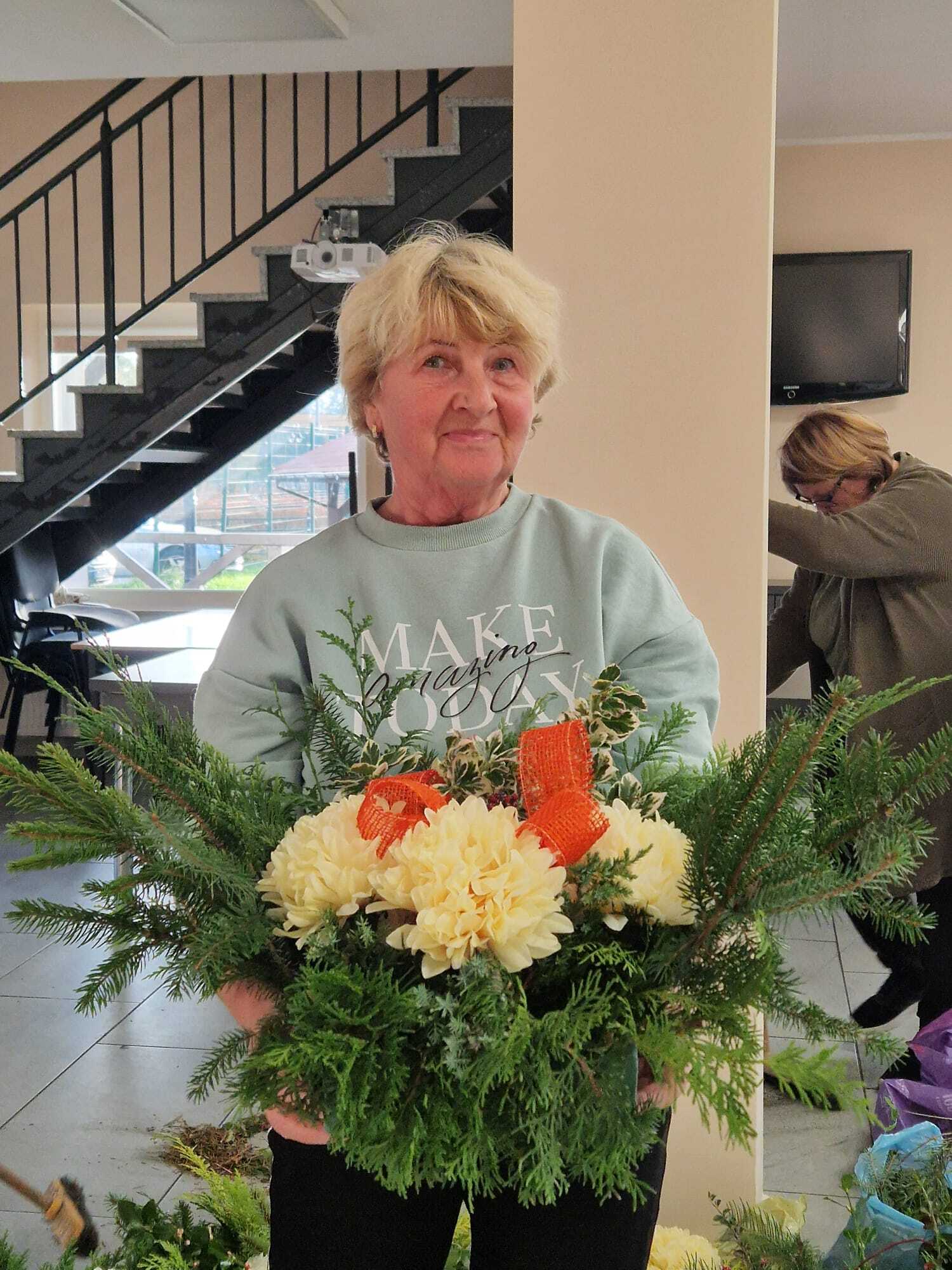 uczestniczka warsztatów prezentująca w dłoniach gotowy stroik