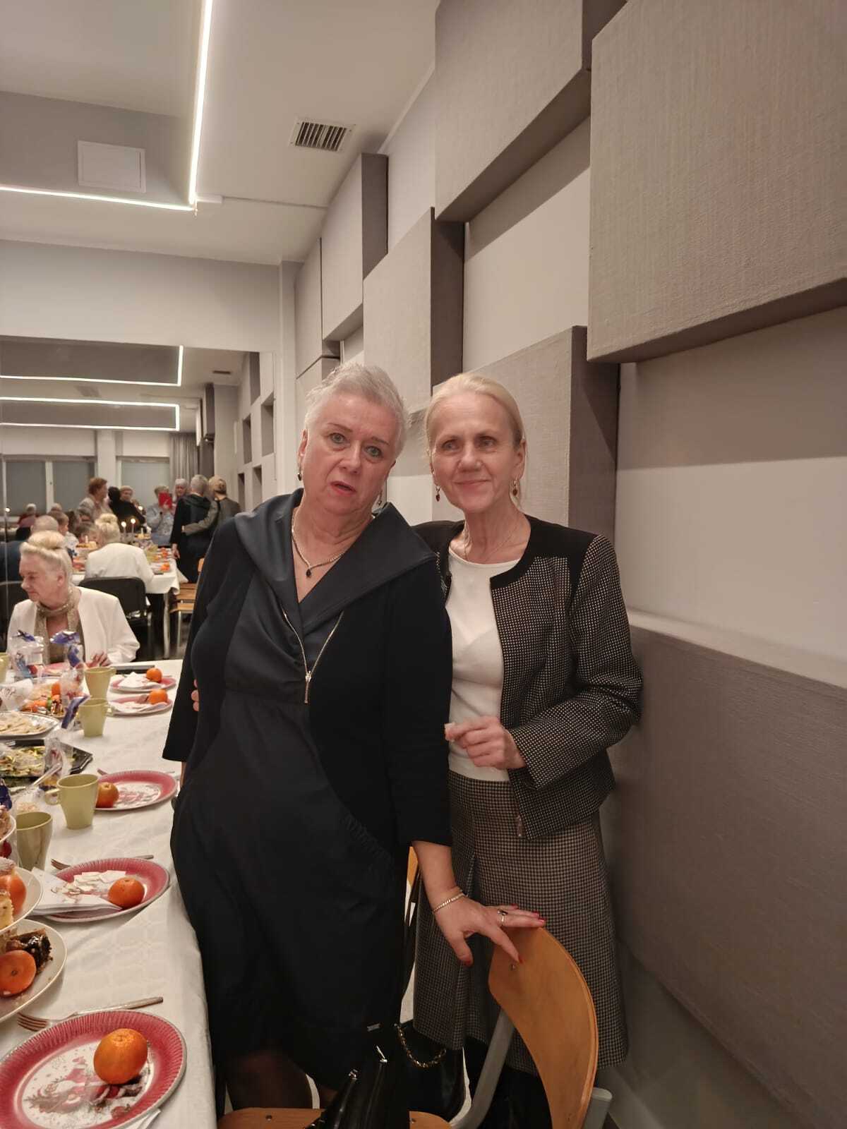 dwiw uczestniczki spotkania stojące przy stole wigilijnym