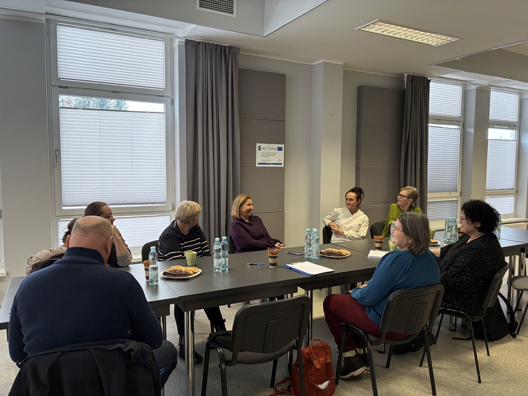 uczestnicy spotkania przy wspólnym stole z prowadzącą